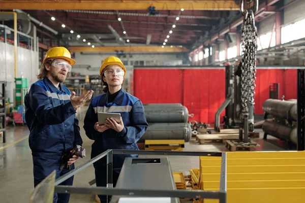 Two mechanics supervising crane parts